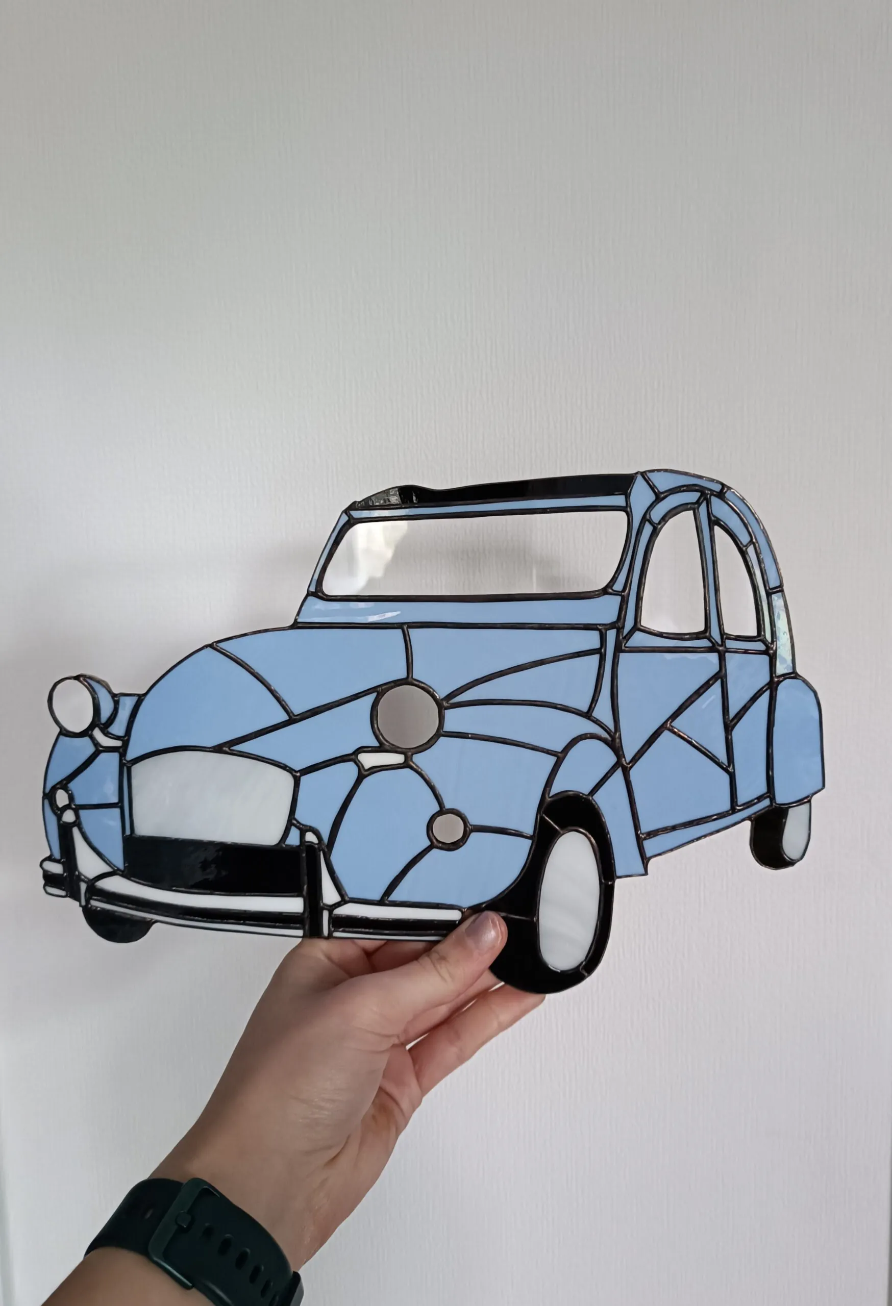 Glas in lood hanger op maat: een licht blauwe auto, het lelijke eendje.