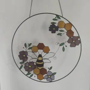 Glas in lood hanger: ring met bloemen, een bij en honingraat.
